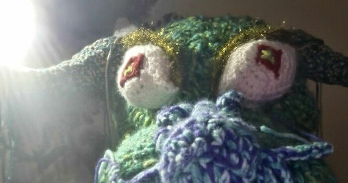 Close-up of a handmade knitted dragon with colorful yarn details, representing Krafty Dragon Industries craftsmanship.