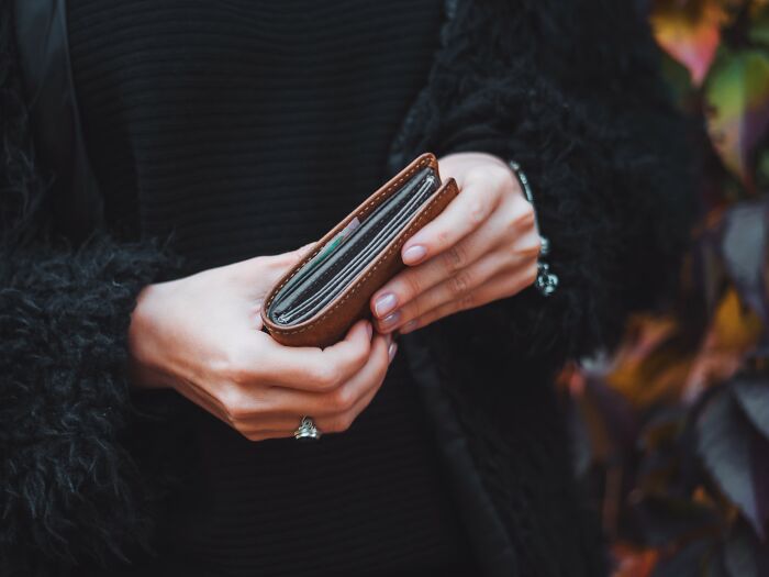 Person holding a brown wallet outdoors, illustrating one of the craziest coincidences people experienced moments.