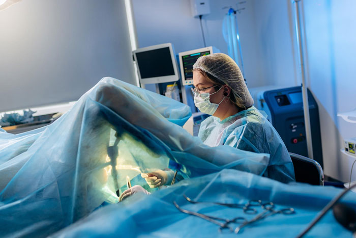 Surgeon performing hysterectomy procedure in operating room, highlighting childfree couple conflict after prank revelation.