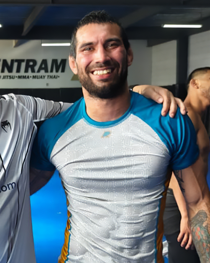 Male jiu-jitsu trainer smiling at gym after tragic freak accident involving paralyzing sparring incident. Male jiu-jitsu trainer smiling at gym after tragic freak accident involving paralyzing sparring incident.