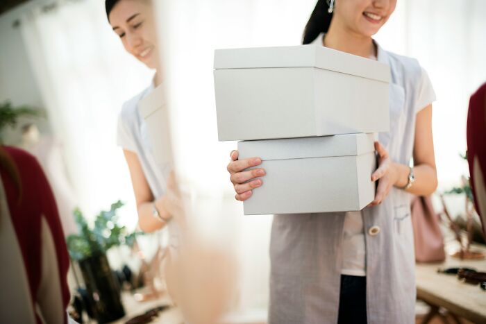 Woman holding two gift boxes, symbolizing a situation involving gifting broken items and a disagreement over it. Woman holding two gift boxes, symbolizing a situation involving gifting broken items and a disagreement over it.