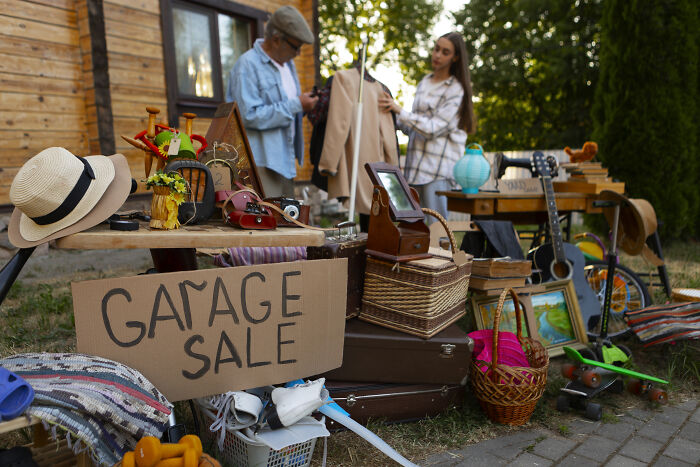 Two women browsing items at a garage sale, highlighting gifting broken stuff and green living concerns. Two women browsing items at a garage sale, highlighting gifting broken stuff and green living concerns.