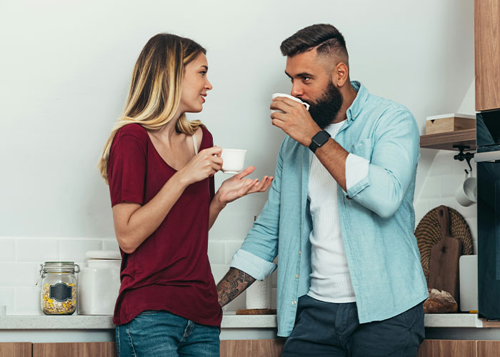 Two people having a serious conversation over coffee, reflecting tension from friendship crumbling after secret exposed.