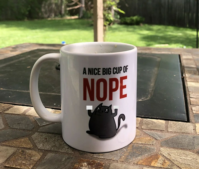 White mug with a cartoon cat and text on a patio table, reflecting a friend who doesn't understand clingy children on vacation. White mug with a cartoon cat and text on a patio table, reflecting a friend who doesn't understand clingy children on vacation.