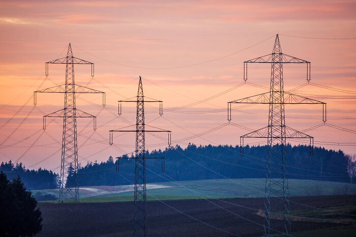 High-voltage power lines at sunset over fields, representing key events in an online thread about what's coming next.