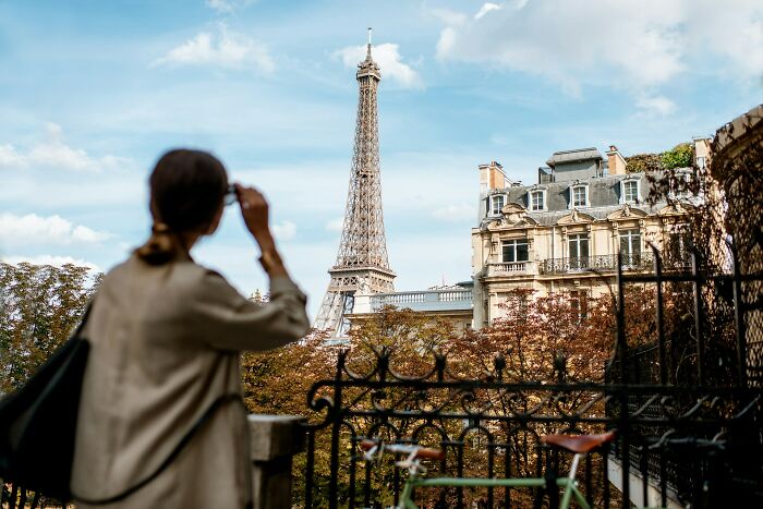 Person looking at the Eiffel Tower in Paris, reflecting on surprising habits and secrets discovered about their partner after moving in.