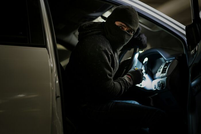 Person wearing a mask inside a car at night, illustrating funny and serious moments parents realized they were raising monsters.