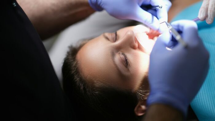 Dentist wearing gloves performing dental procedure on a patient, highlighting wildest patient horror stories in dentistry.