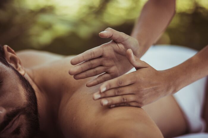 Person receiving a relaxing back massage with hands applying work secrets of skilled care and service professionals