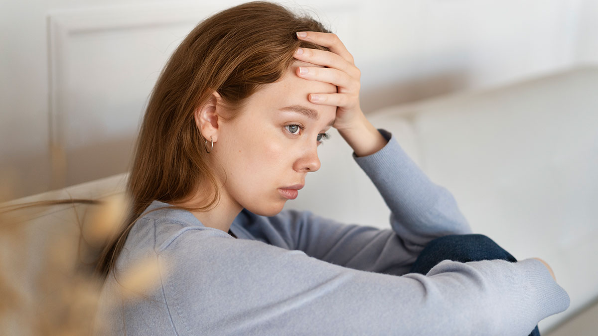 Young woman looking distressed and thoughtful, reflecting on parents demanding career opportunity for golden-child sister