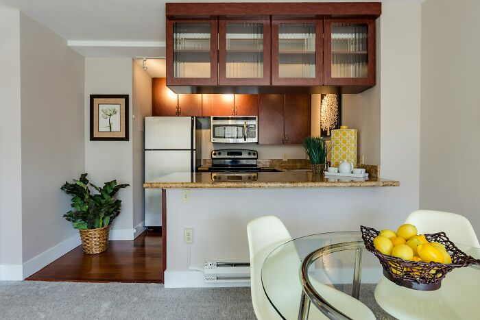 Modern kitchen with stainless steel appliances and a dining table, illustrating a home setting for siblings discussing moving in.
