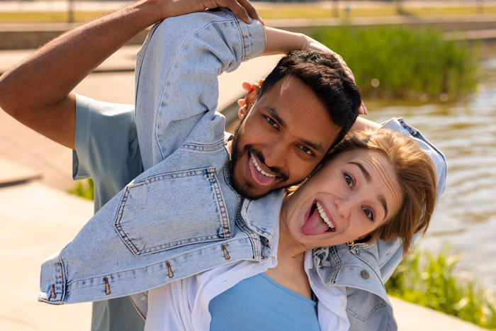 Young couple laughing near water, highlighting the Indian grandmother demands DNA test over baby's pale skin claim. Young couple laughing near water, highlighting the Indian grandmother demands DNA test over baby's pale skin claim.