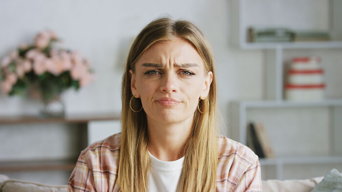 Suspicious woman expressing doubt and concern while sitting indoors, reflecting feelings of something being off in relationship. Suspicious woman expressing doubt and concern while sitting indoors, reflecting feelings of something being off in relationship.
