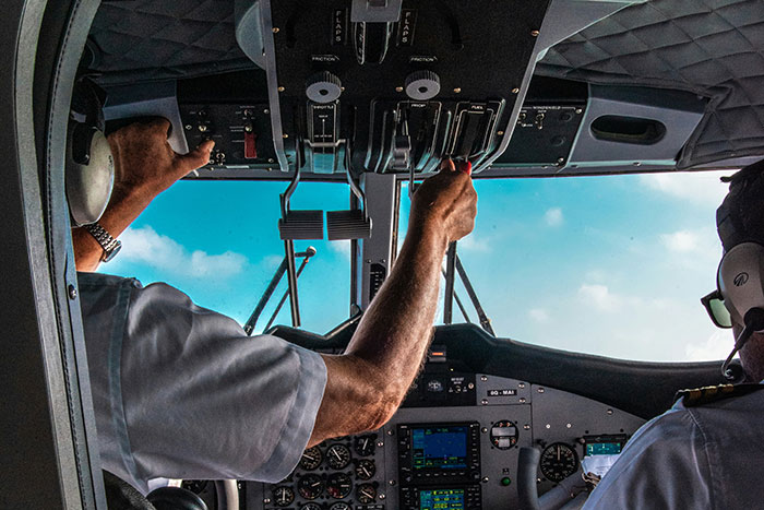 Cockpit view with pilots operating controls, showcasing secrets about planes and flying from a passenger perspective.