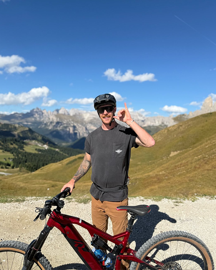 Man with helmet and sunglasses standing next to mountain bike, representing jiu-jitsu trainer after tragic freak accident incident. Man with helmet and sunglasses standing next to mountain bike, representing jiu-jitsu trainer after tragic freak accident incident.