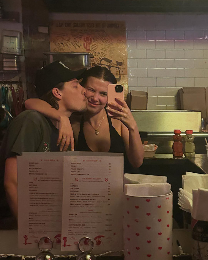 Jake Bongiovi kissing Millie Bobby Brown while taking a selfie, highlighting criticism about not helping protect their baby. Jake Bongiovi kissing Millie Bobby Brown while taking a selfie, highlighting criticism about not helping protect their baby.