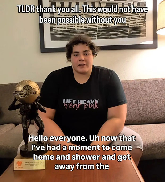 Person sitting on a couch beside a strongman trophy, discussing the world's strongest woman and related controversy. Person sitting on a couch beside a strongman trophy, discussing the world's strongest woman and related controversy.