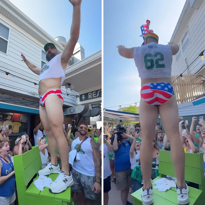 Man in patriotic underwear and cropped top dancing energetically at crowded outdoor party, sparking celebrity reveal frenzy. Man in patriotic underwear and cropped top dancing energetically at crowded outdoor party, sparking celebrity reveal frenzy.