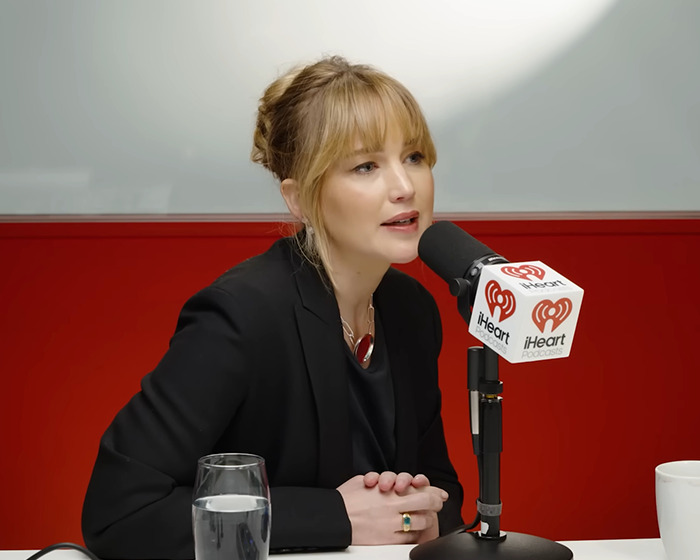 Jennifer Lawrence speaking into a microphone during an iHeart podcast interview about male co-stars punishing her. Jennifer Lawrence speaking into a microphone during an iHeart podcast interview about male co-stars punishing her.