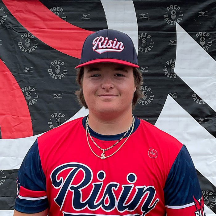 Teen wearing Risin baseball uniform and cap standing in front of a banner at a baseball event in Oklahoma protests. Teen wearing Risin baseball uniform and cap standing in front of a banner at a baseball event in Oklahoma protests.