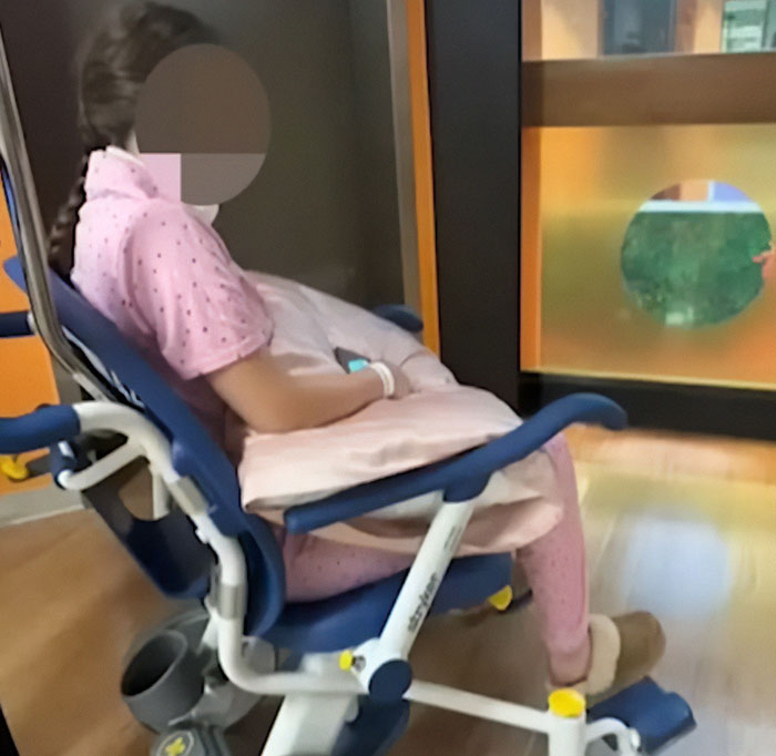 Person in pink outfit sitting in a hospital chair, symbolizing protests erupting across Oklahoma after teen walks free Person in pink outfit sitting in a hospital chair, symbolizing protests erupting across Oklahoma after teen walks free