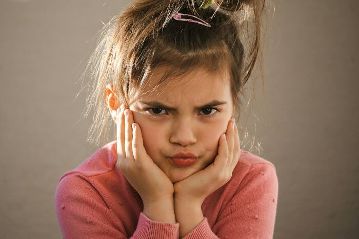 Young girl making a funny angry face, illustrating funny and serious moments parents realized they were raising monsters.