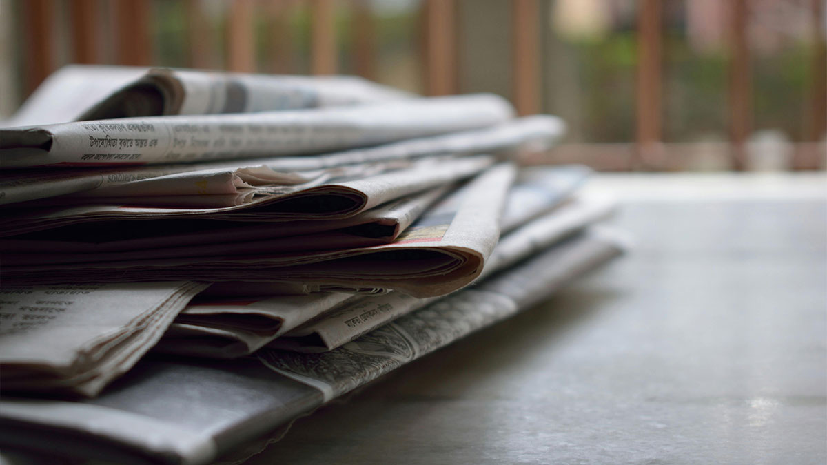 Stack of newspapers on a table representing clever cleaning hacks inspired by laziness and simple everyday solutions.
