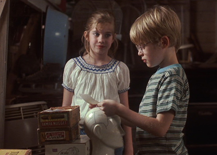 Scene from My Girl with two children looking at a photograph, revealing the terrifying truth behind its filming. Scene from My Girl with two children looking at a photograph, revealing the terrifying truth behind its filming.