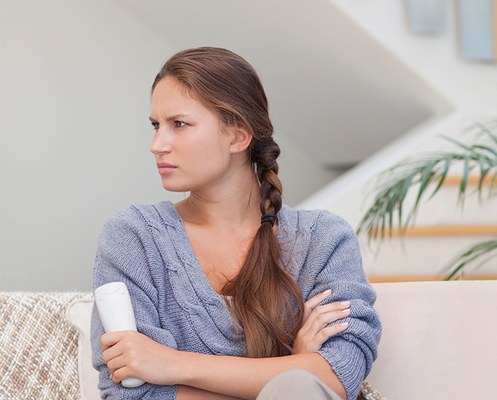 Woman ask stepchildren about home boarding school, sitting with crossed arms and concerned expression indoors. Woman ask stepchildren about home boarding school, sitting with crossed arms and concerned expression indoors.