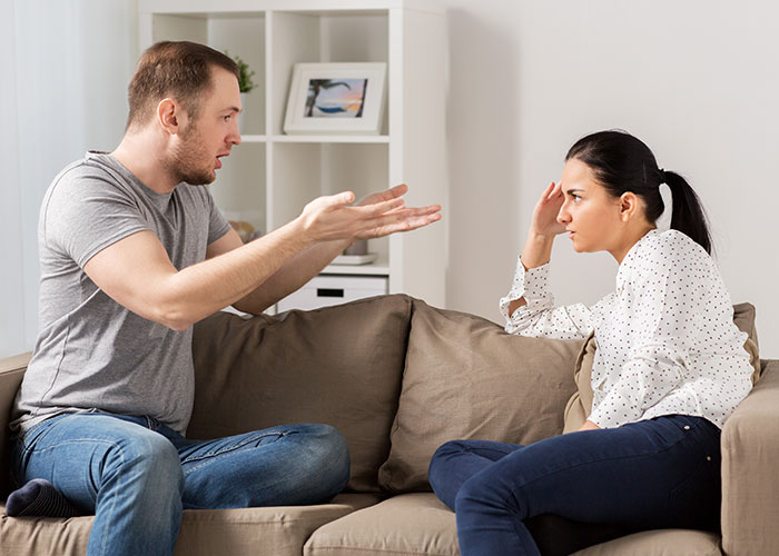 Man and teen girl arguing intensely on couch, showing tension and rude attitude in family setting.