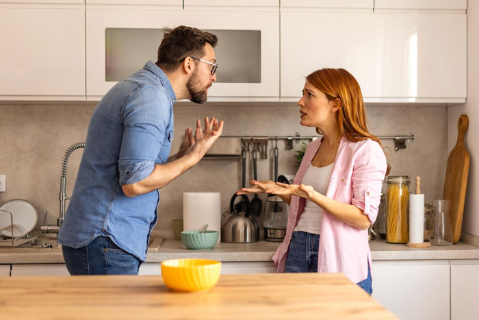 A man and a woman arguing in a kitchen, showing tension over traditional roles and cooking responsibilities.