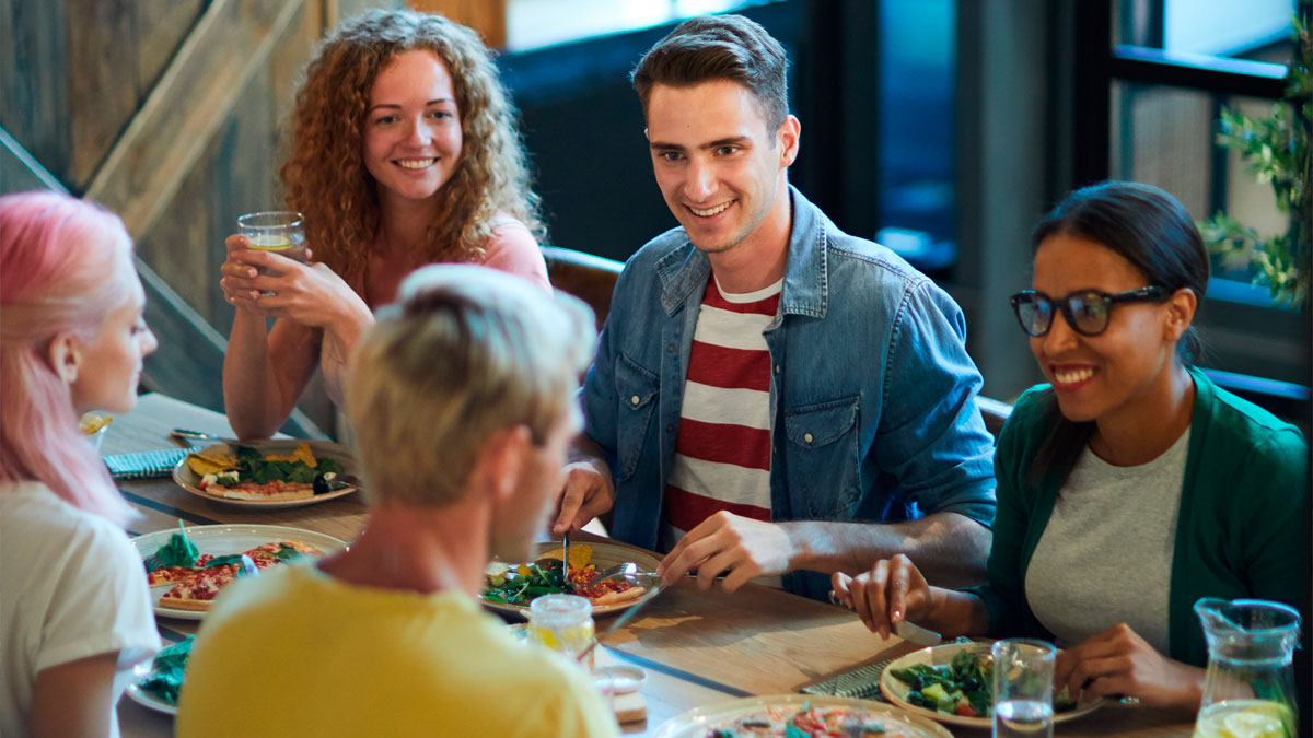 Group of friends enjoying a meal together, discussing a rich man refusing to pay for a cake ordered by SIL.