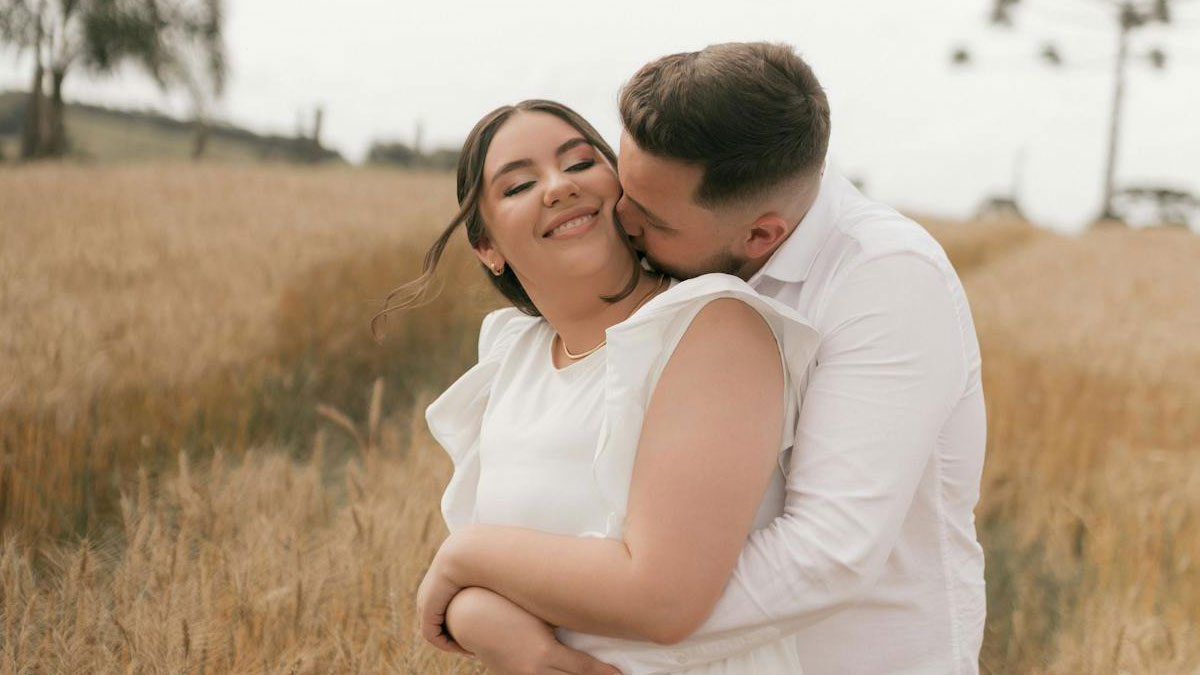 Couple embracing happily in a wheat field, illustrating the reality and harsh truths about marriage experienced by people.