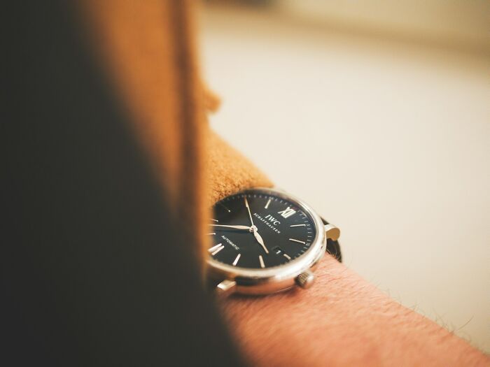 Close-up of a wristwatch on a person's arm symbolizing ways people found out about a significant other's unfaithful behavior.