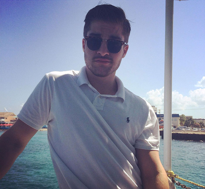 Young man wearing sunglasses and a white polo shirt posing outdoors by the water inspired by the next Brad Pitt viral sensation. Young man wearing sunglasses and a white polo shirt posing outdoors by the water inspired by the next Brad Pitt viral sensation.