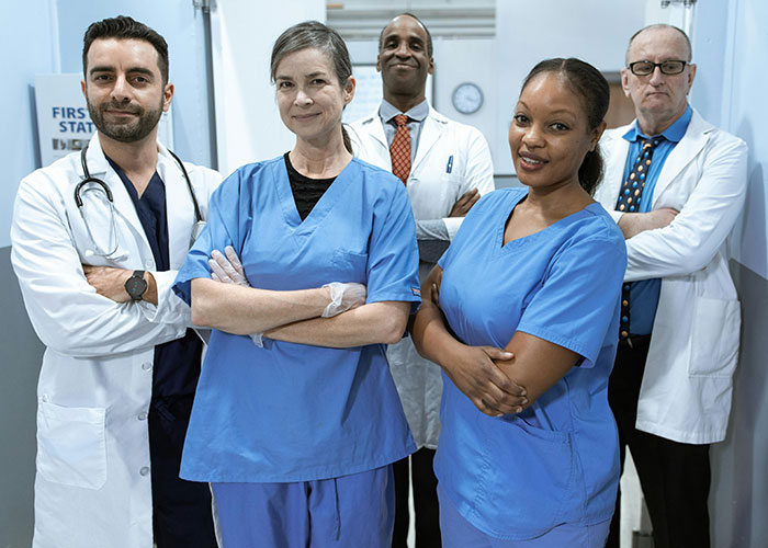 Diverse medical team including doctors and nurses posing confidently, related to medical malpractice lawyer insights.