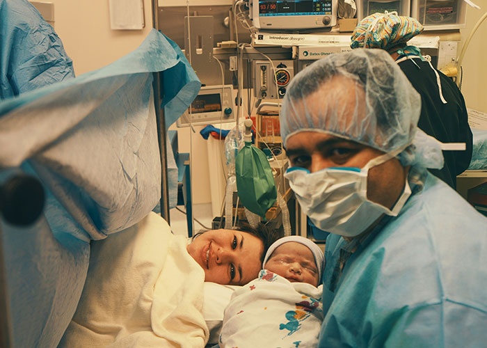 New parents in a hospital room with newborn baby, highlighting medical malpractice lawyer insights on everyday dangers.