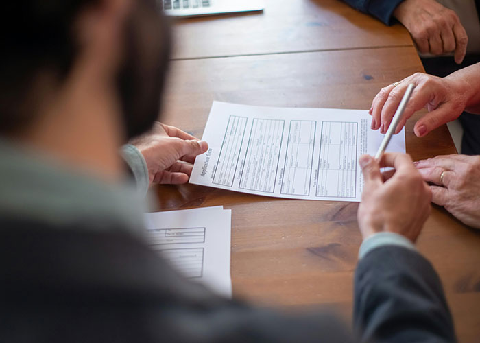 Medical malpractice lawyer reviewing documents with clients discussing cases about dangerous things in everyday life.