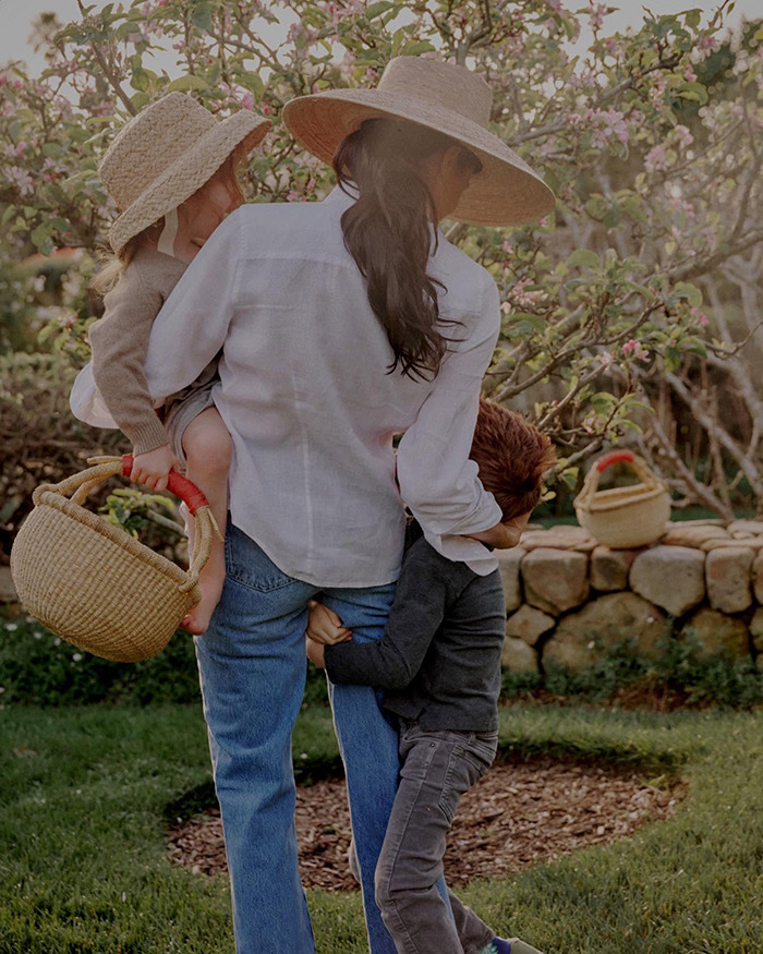 Woman and children in garden setting, natural light, portraying a scene related to Meghan Markle Thanksgiving turkey faux pas. Woman and children in garden setting, natural light, portraying a scene related to Meghan Markle Thanksgiving turkey faux pas.
