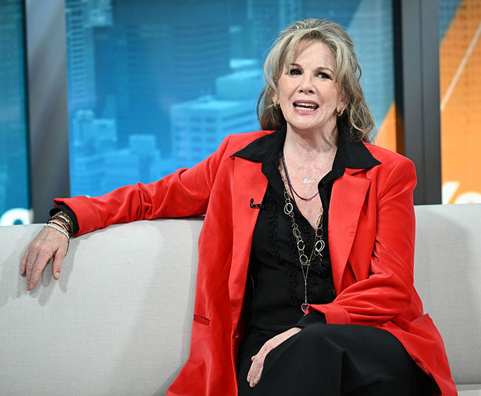 Melissa Gilbert seated on a couch during an interview, wearing a red jacket and black outfit, discussing age gap feelings. Melissa Gilbert seated on a couch during an interview, wearing a red jacket and black outfit, discussing age gap feelings.