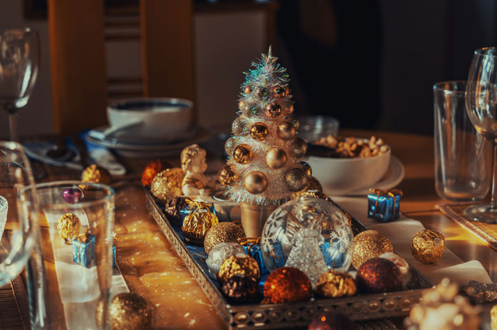 Festive table centerpiece with Christmas ornaments reflecting a blended family holiday setting conflict at dinner.