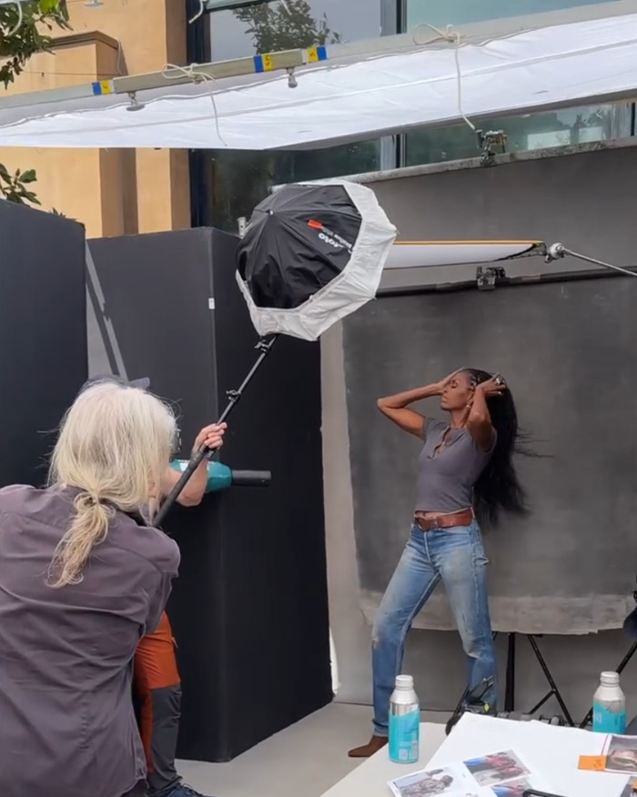 Woman with ultra-long hair posing in casual outfit during a photoshoot highlighting natural hair and style trends.
