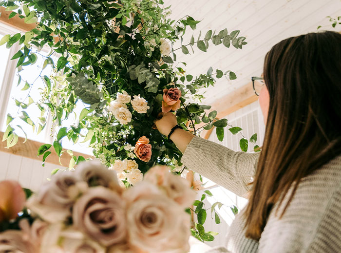 Bride arranging flowers for wedding decor, highlighting secret wedding invites and protecting family image. Bride arranging flowers for wedding decor, highlighting secret wedding invites and protecting family image.