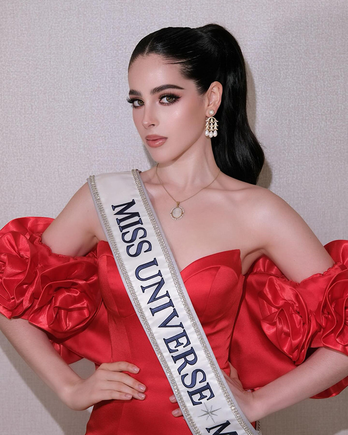 Miss Mexico at Miss Universe pageant wearing red dress and sash, posing confidently amid drama at the event. Miss Mexico at Miss Universe pageant wearing red dress and sash, posing confidently amid drama at the event.
