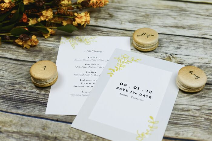 Wedding invitations and macarons with calligraphy on a rustic wooden table, highlighting wedding event planning. Wedding invitations and macarons with calligraphy on a rustic wooden table, highlighting wedding event planning.