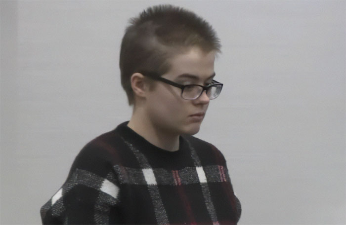 Young man with glasses wearing black plaid sweater appearing focused in an indoor setting, related to Slender Man attacker case. Young man with glasses wearing black plaid sweater appearing focused in an indoor setting, related to Slender Man attacker case.