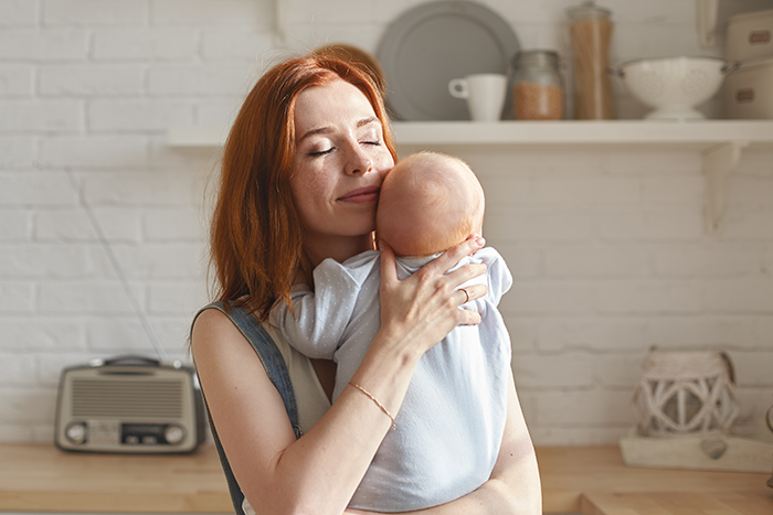 Woman gently holding a newborn baby nephew, reflecting sibling refuse newborn nephew care concerns in a bright kitchen. Woman gently holding a newborn baby nephew, reflecting sibling refuse newborn nephew care concerns in a bright kitchen.