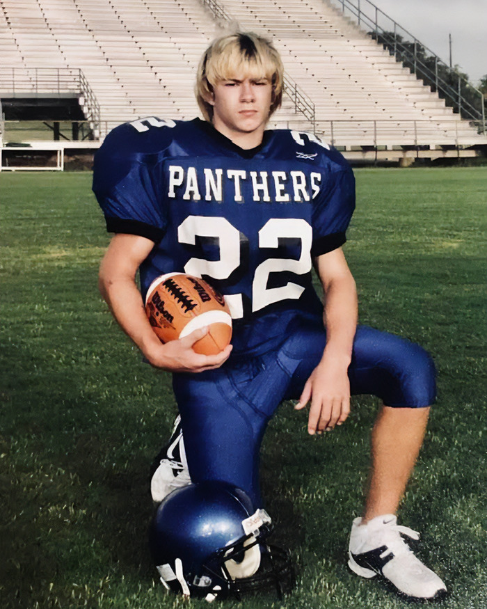 Teen football player kneels on field in Panthers uniform, linked to mom's claim about skinned body in Las Vegas museum.