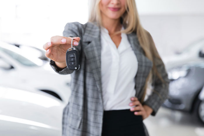 Woman holding car key fob confidently in a car dealership, symbolizing panic alarm and neighbor helping story. Woman holding car key fob confidently in a car dealership, symbolizing panic alarm and neighbor helping story.