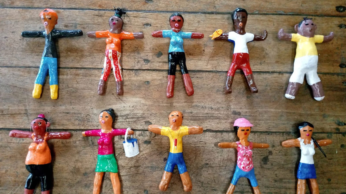 Colorful handmade dolls arranged on wooden surface symbolizing womanu2019s unexpected savage revenge on petty neighbor.